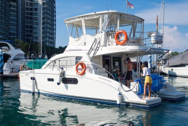 An exterior view of a catamaran with people onboard