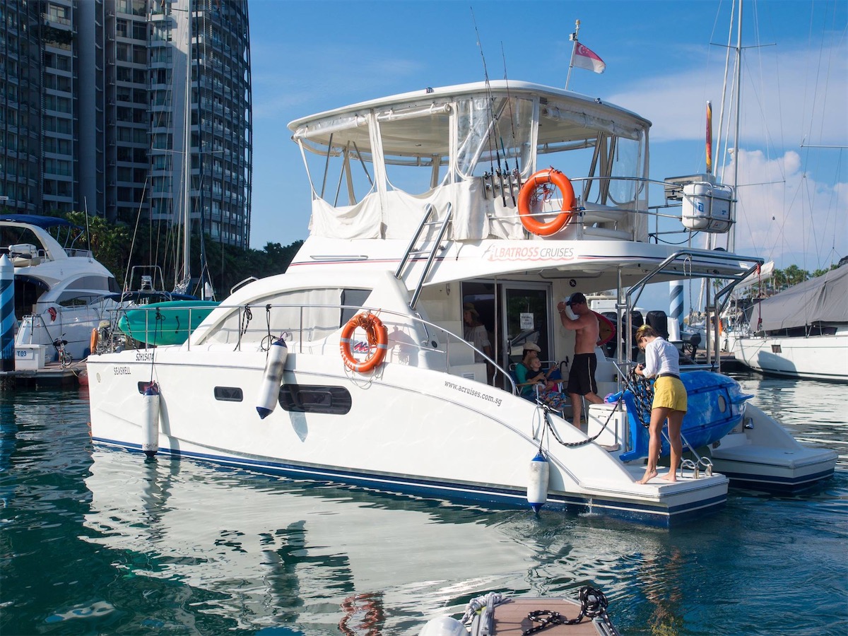 An exterior view of a catamaran with people onboard