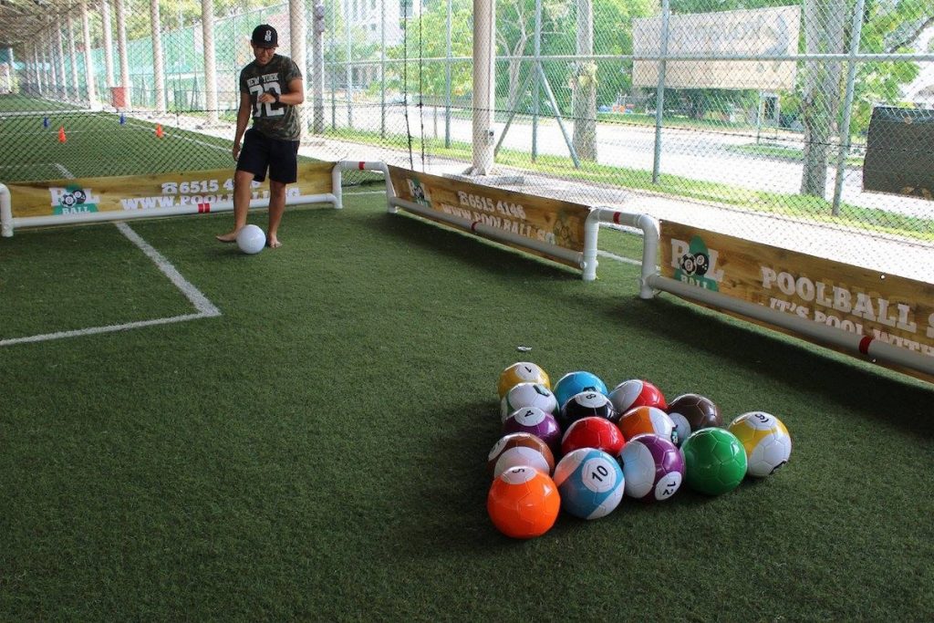 A man getting ready to kick the white ball